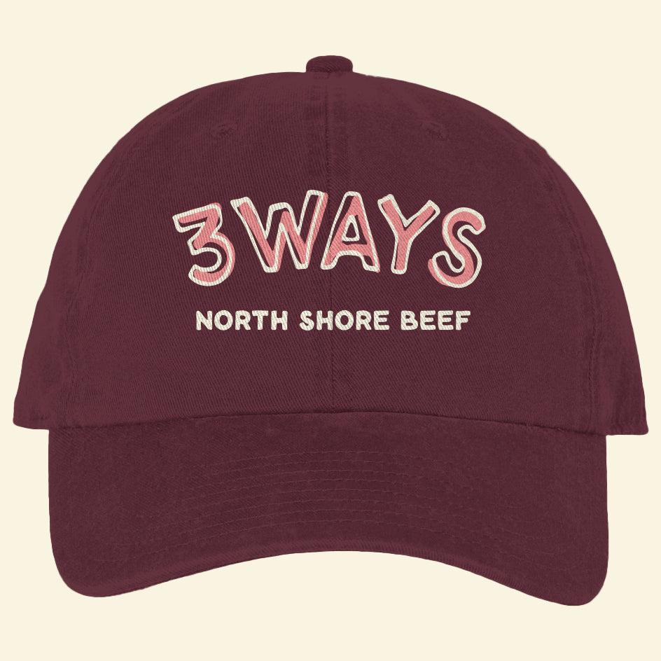 Maroon hat with horizontal pink and off white 3Ways North Shore Beef logo