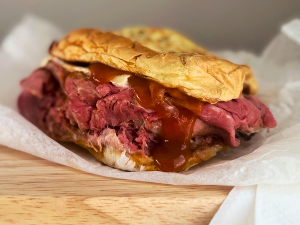 Close-up North Shore Beef dripping with James River BBQ Sauce on a toasted bun.
